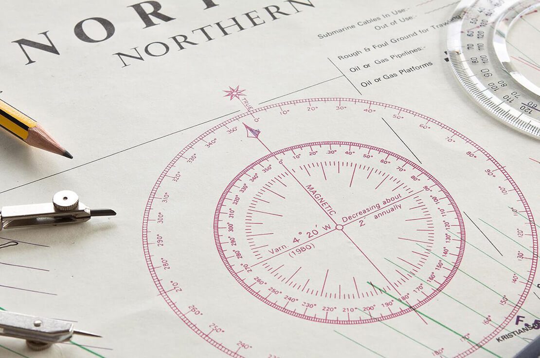 A navigation charting map with compass and a calculator